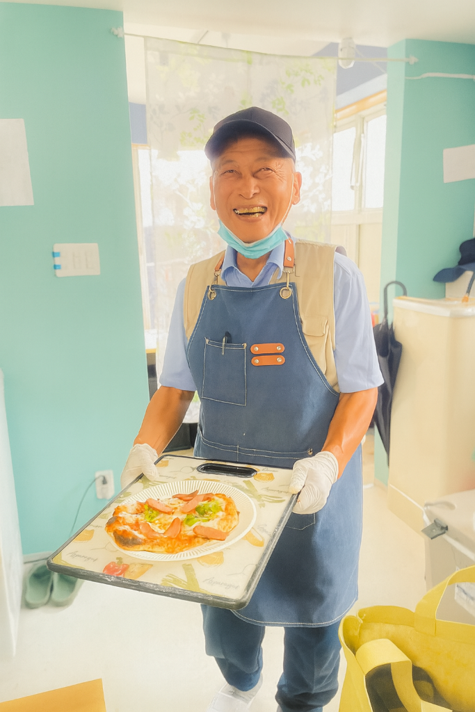 笑顔でお惱荘を持つスタッフ